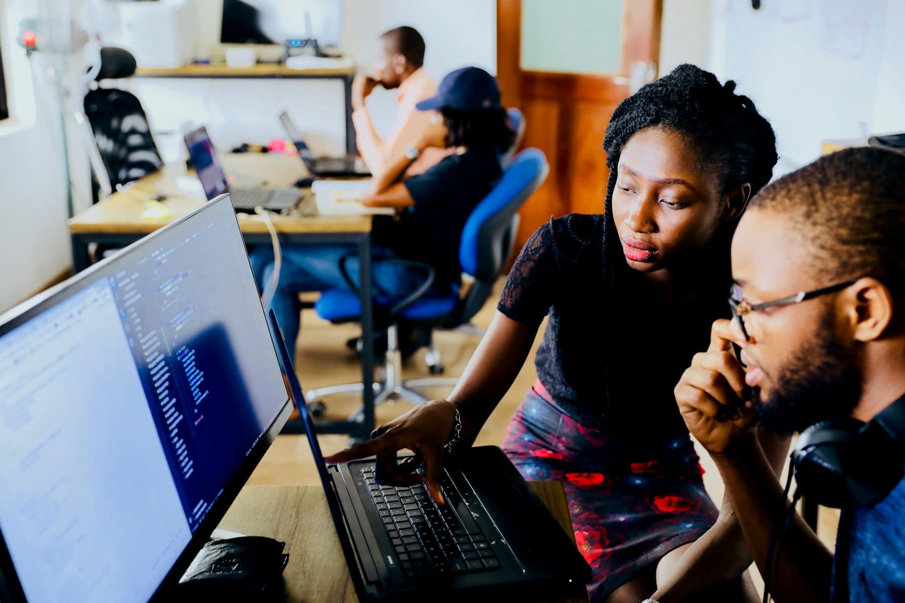 Two developers reviewing code together on a monitor